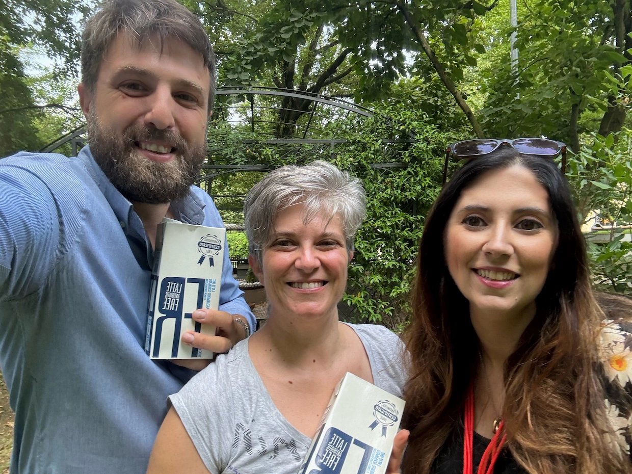 immagine di tre volontari della Casa del Giovane di Pavia con in mano il latte antibiotic free donato da Mc Elan